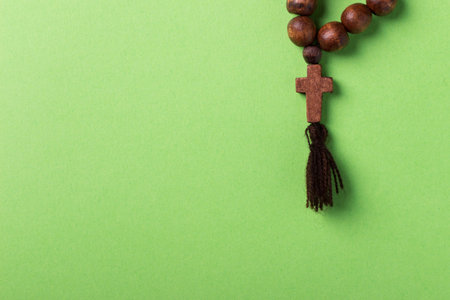 Wooden rosary and cross on green background.の写真素材