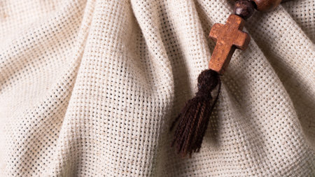 Wooden rosary and cross on linen cloth background.の写真素材