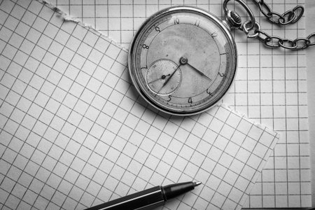 Old clock, pages of paper in a cage, a pen on a wise book. Concept of education. Black and white photographyの写真素材