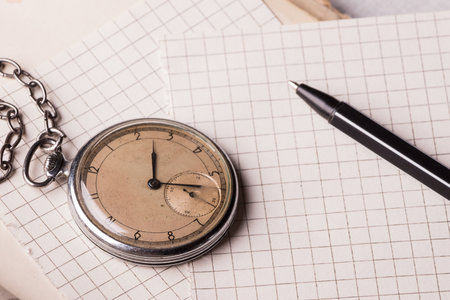 Old clock, pages of paper in a cage, a pen on a wise book. Concept of education.の写真素材