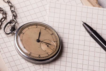 Old clock, pages of paper in a cage, a pen on a wise book. Concept of education.の写真素材