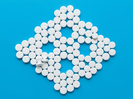 White pills on blue background. Focus on foreground, soft bokeh.の素材