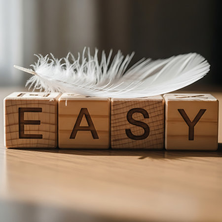 Wooden block spelling easy with soft white feather on topの素材