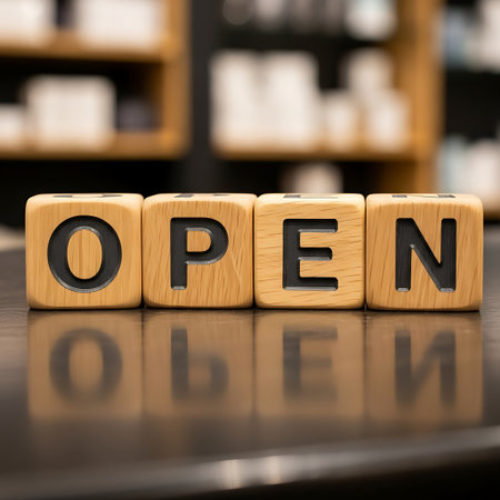 Wooden block letters spelling open sitting on a reflective surfaceの素材