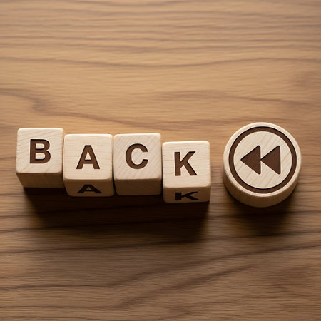 Wooden block spelling back next to a rewind media control buttonの素材