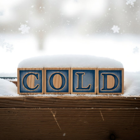 Wooden block spelling cold covered in snow on windowsillの素材