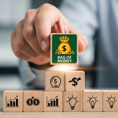 Hand holding wooden block with bag of money icon above othersの素材