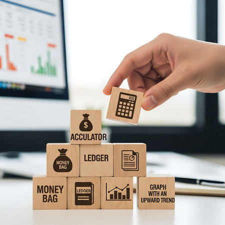 Hand placing calculator block on stack of finance and accounting wooden cubesの素材