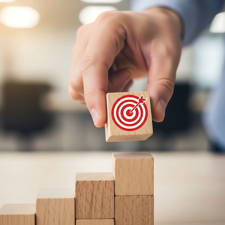Hand placing wooden block with target symbol on growing stackの素材