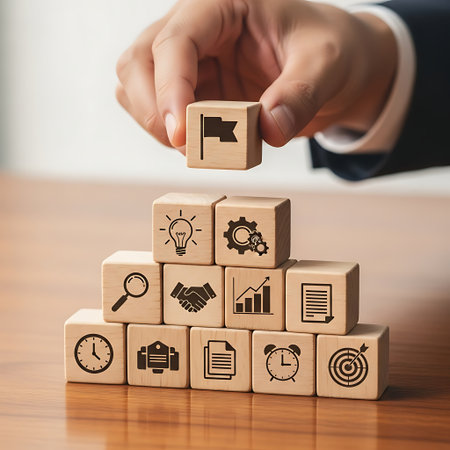 Hand placing wooden block with flag icon on top of business strategy blocksの素材