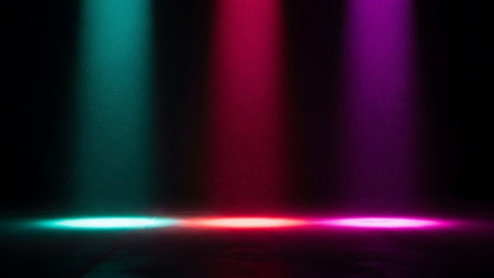 Three colorful stage spotlights shining down on a dark floorの素材