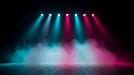 Stage lighting with blue and pink spotlights illuminating smoke and floorの素材