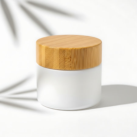 White cosmetic cream jar with bamboo lid casting shadow on white backgroundの素材