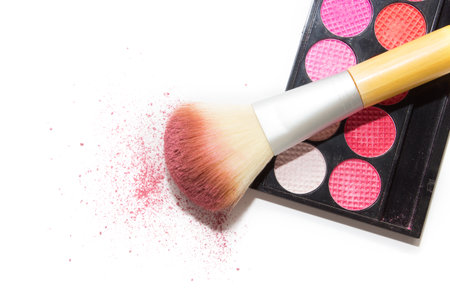 Pink eyeshadows, big cosmetic brush and blush on white background isolated