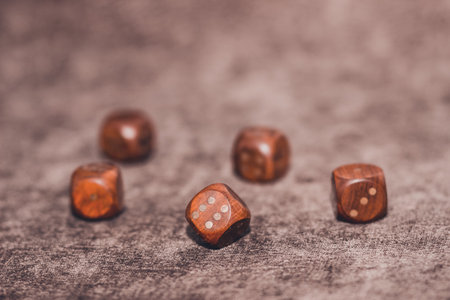 Five wooden dices lying on brown velvet backgroundの写真素材