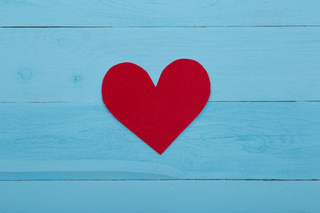 Red paper heart on blue wooden boards, view from aboveの写真素材