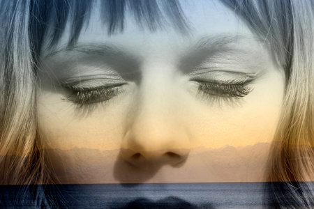 Double exposure of girl with closed eyes and seaside relaxation mountainscapeの写真素材