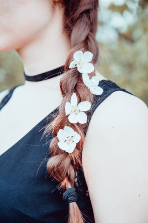 Close up view of young woman's tress with cherry flowers within, vintage style photoの写真素材