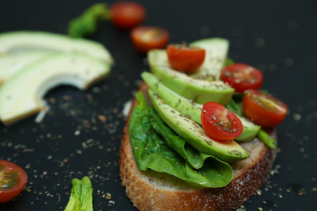 Close up of healthy toast with spinach leaves, avocado and tomaties. Diet idea for breakfast.