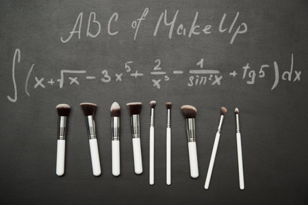 Set of make up brushes on black background with chulk pictures. ABC of make up concept.