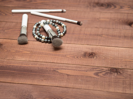 Collection of white make up brushes on brown wooden tableの写真素材
