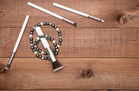 Collection of white make up brushes on brown wooden tableの写真素材