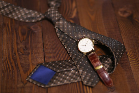 Flat lay shot of Men fashion accessories. Brown watch, tie on wooden background. Still life. Business look.の写真素材