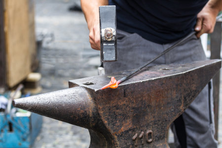 Traditional style blacksmith at work. Hammer hands and iron.