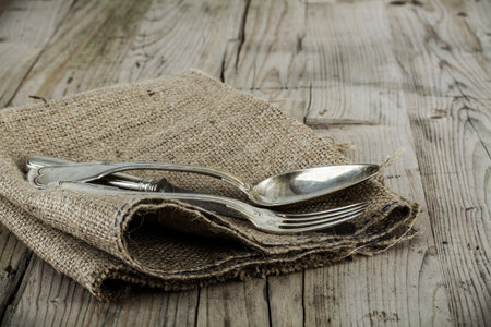 Vintage silver knife, fork and spoon on a rustic weathered table.の写真素材