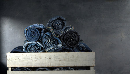 rolled jeans over old grungy  wall backgroundの写真素材