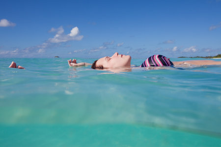 A young woman in a bikini floating on waterの写真素材