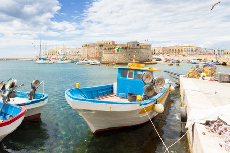 Gallipoli, Apulia, Italy - Fishing boat at the seaport in front of the town wallの写真素材