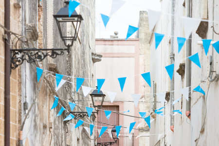 Presicce, Apulia, Italy - Blue and white bunting in the streets to celebrateの写真素材
