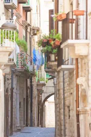 Molfetta, Apulia, Italy - Old balconies and a historical archway in an alleyway of Molfettaの写真素材