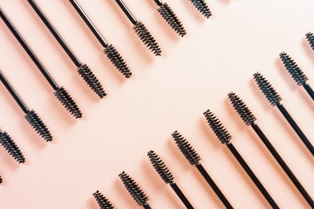 Black brushes and applicators for eyelashes and eyebrows on pink background. Womens cosmetics. Makeup for the face.の写真素材