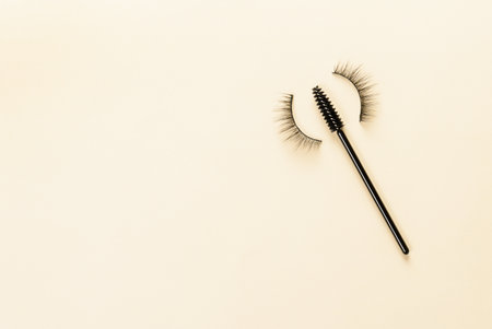 Overhead eyelashes and brushes on yellow background. Makeup of female eyes. Eyelash extension. Piece care.の写真素材