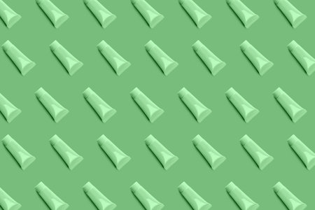 Blank tube layout on green background. Cosmetic product. Skin care. Female hygiene. Pattern.の写真素材
