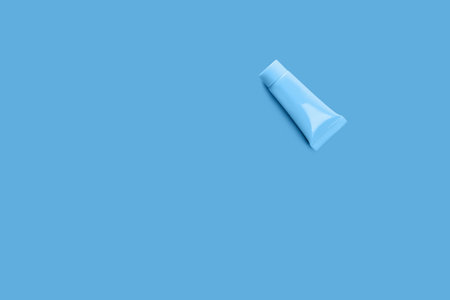 Blank tube layout on blue background. Cosmetic product. Skin care. Female hygiene.