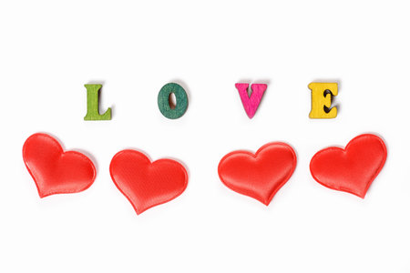 Inscription love made of wooden letters with hearts for Valentines Day. Festive hearts for...