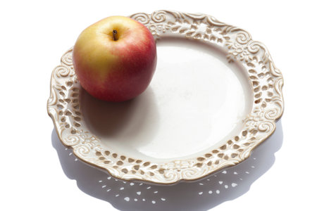 One apple on a beautiful plate on whiteの写真素材