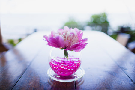 beautiful pink peony in vase with balls on the table outdoorの写真素材