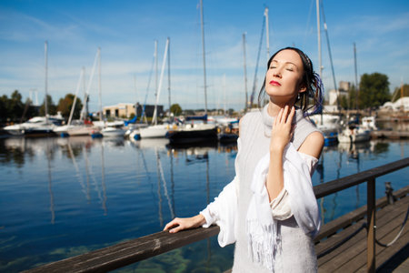 Japanese woman at the pier near yacht on the background of blue skyの写真素材