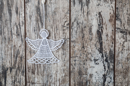Gray wooden background with crocheted angel for Christmas cardの写真素材