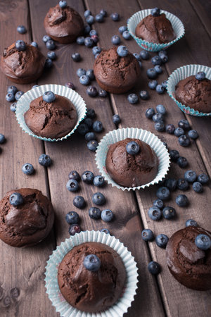 Chocolate cupcakes with blueberries on wooden table. Top viewの写真素材