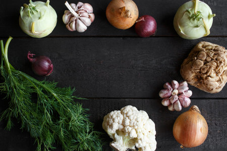 Spring vegetables on a dark background: cauliflower, onion, garlic, kohlrabi, celery root, dillの写真素材