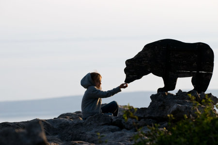 Girl is playing that she is feeding the bearの写真素材