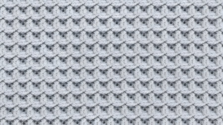 Textured background of light grey knitted fabric. Distinct bubble or scale pattern. Close up view shows intricate textile details. Cozy warmth suitable for winter themes.の素材