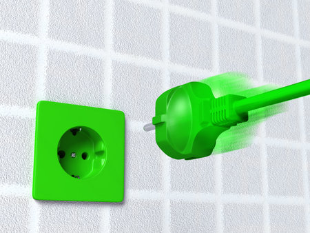 ecological european green plug is going into a green socket placed on the wallの写真素材