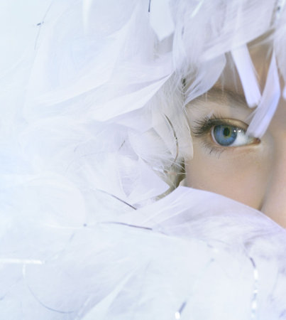 The angel has perfect light-blue eyes and white feathersの写真素材