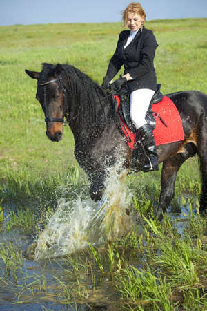horsewoman and her horse /  spray waterの写真素材